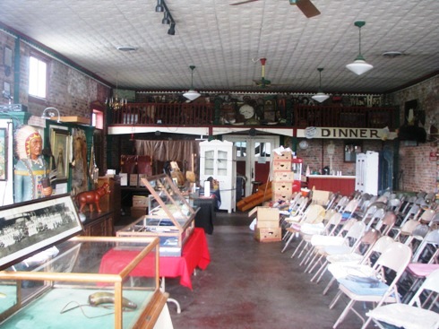 The auction is ready to go! Cool cigar store Indian on the left.