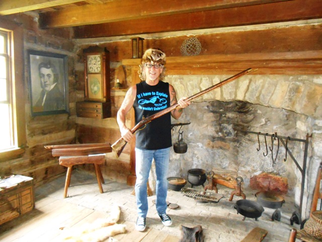 Jeff in a coon skin hat holding a pioneer rifle.